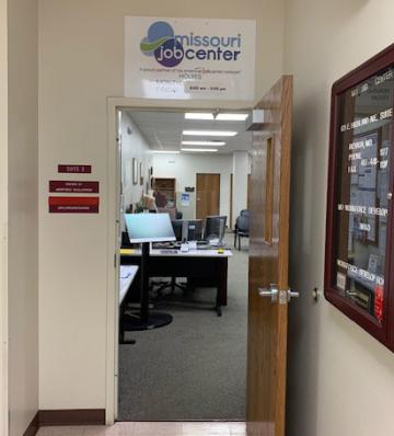 The Indoor entrance to the Nevada Job Center. It is open to show a bit of the interior of the Job Center. There is a sign on top of the door.