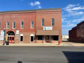 The exterior of the West Plains Job Center. The photo has been taken from across the street, showing a brick storefront. 